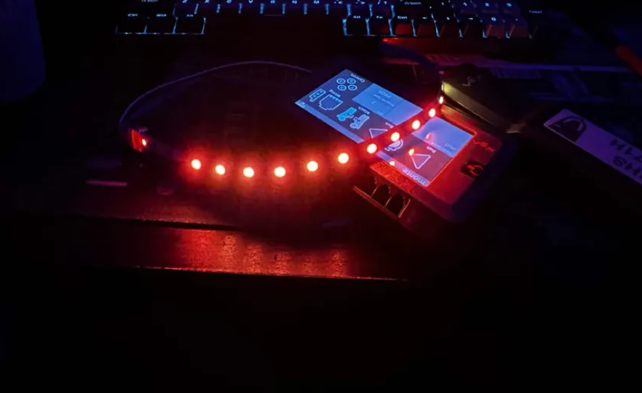 A WS2812B LED strip lit red, wired straight into a VEX Brain on a desk at night
